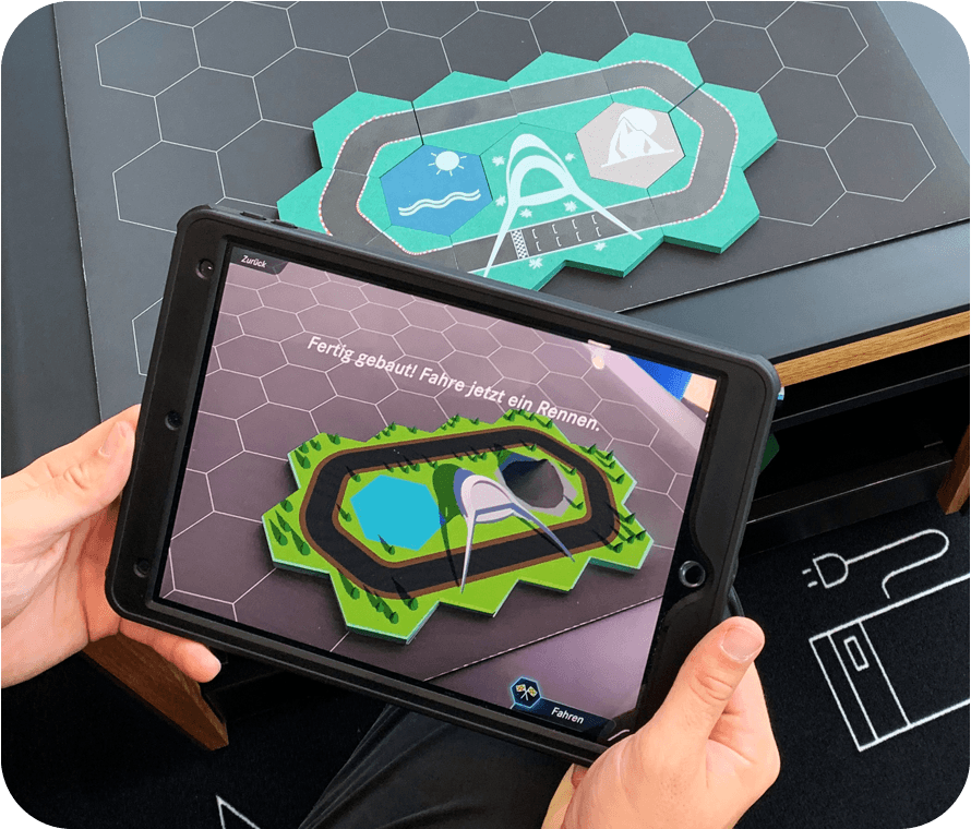 AR-Scan des physischen Spielbretts generiert auf dem iPad eine 3D-Rennstrecke